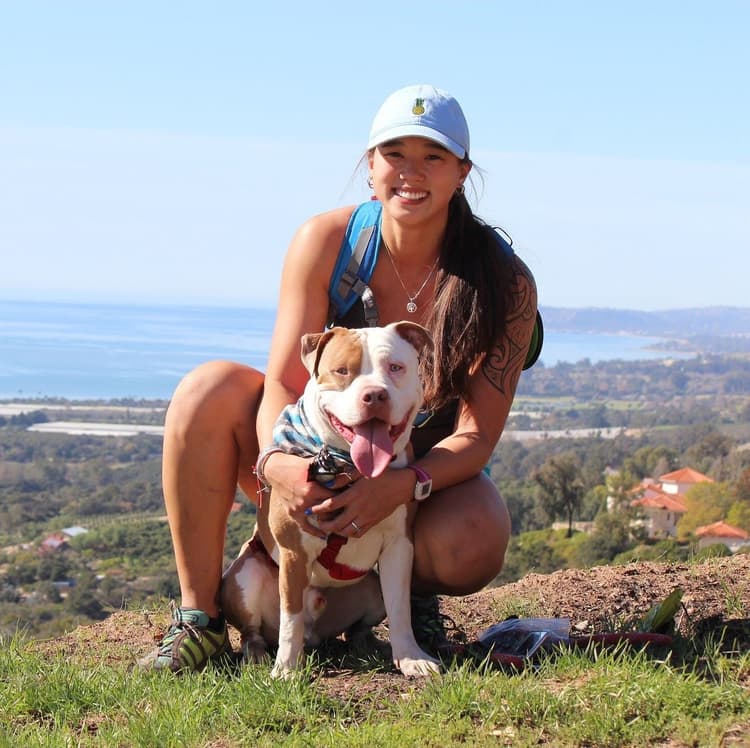 Kim, the artist behind Doodles n Plants, smiling outdoors with her dog Nugget