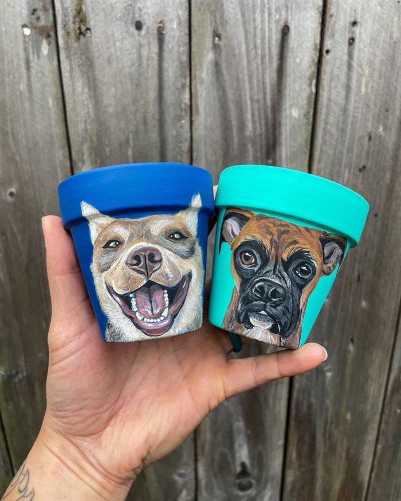 Two hand-painted pots — a smiling dog on blue and a boxer on teal
